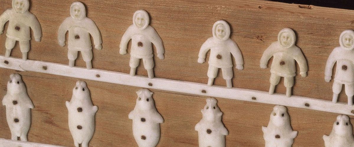 Ivoren mensen- en dierenfiguren op een houten kistje